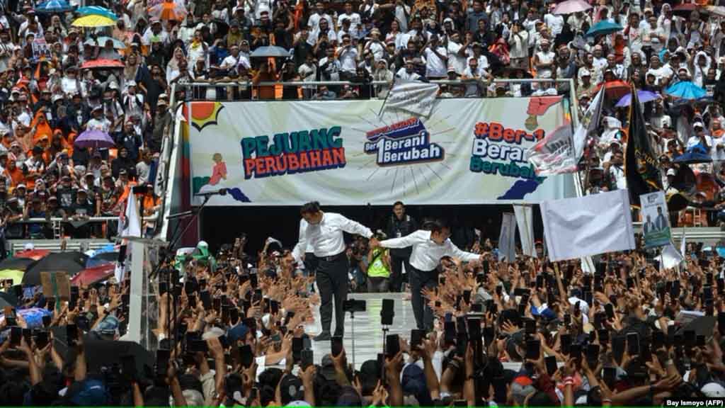 Calon presiden dan wakil presiden, Anies Baswedan (tengah) dan Muhaimin Iskandar (belakang tengah), menyapa pendukungnya saat kampanye di Jakarta International Stadium, Jakarta pada 10 Februari 2024. (Foto: AFP/Bay ismoyo)