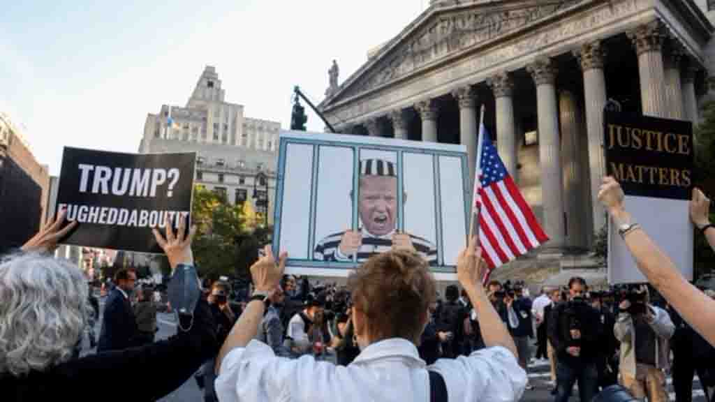 Demonstran anti-Trump memegang poster terkait kasus penipuan perdata yang diajukan oleh Jaksa Agung negara bagian Letitia James, di New York City, AS, 2 Oktober 2023. (Foto: REUTERS/Caitlin Ochs)